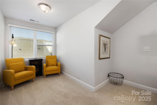 sitting room with vaulted ceiling and light carpet