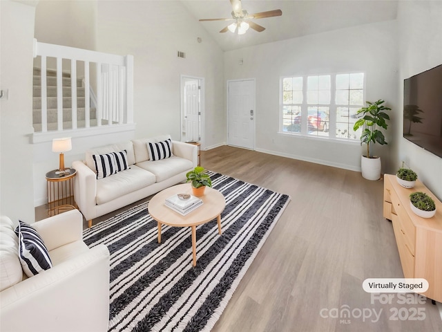 living room featuring ceiling fan, high vaulted ceiling, and light hardwood / wood-style floors