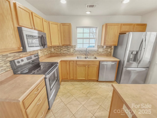 kitchen with sink, decorative backsplash, stainless steel appliances, and light brown cabinets