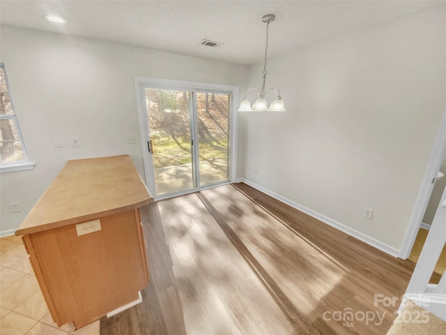 unfurnished dining area featuring a notable chandelier