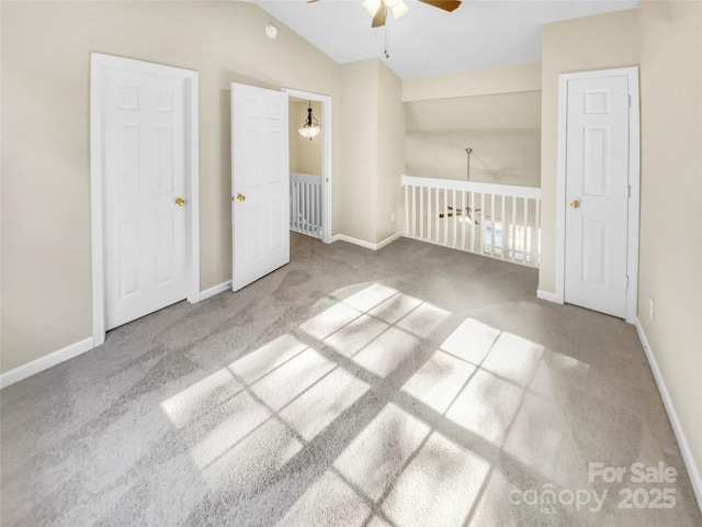 carpeted empty room featuring ceiling fan and vaulted ceiling