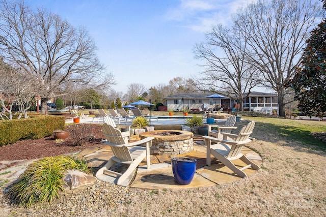 view of yard with a patio, a swimming pool, and an outdoor fire pit