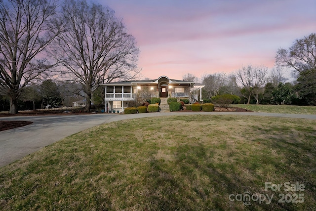 view of front of property featuring a yard and a sunroom