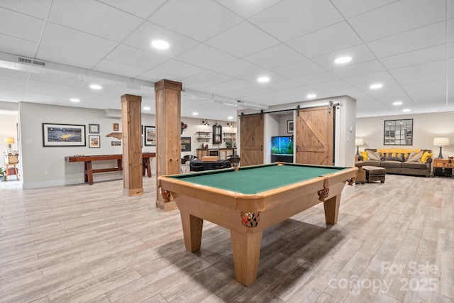 game room with a drop ceiling, billiards, a barn door, and light wood-type flooring