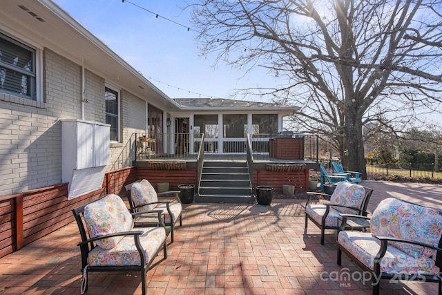 view of patio featuring a sunroom