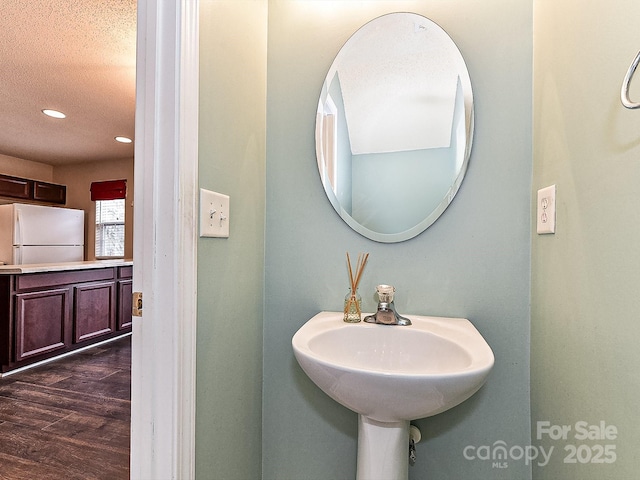 bathroom featuring hardwood / wood-style floors and a textured ceiling