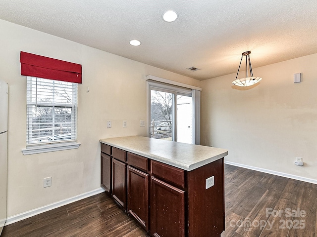 kitchen featuring hanging light fixtures, dark wood-type flooring, and kitchen peninsula