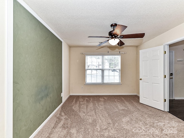 carpeted empty room with ceiling fan and a textured ceiling