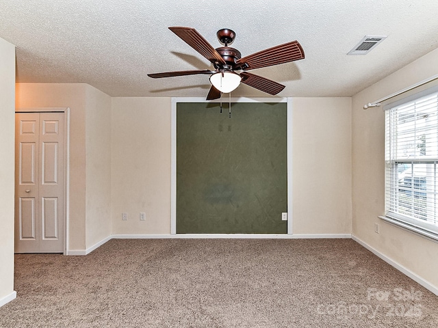 spare room featuring ceiling fan, carpet floors, and a textured ceiling