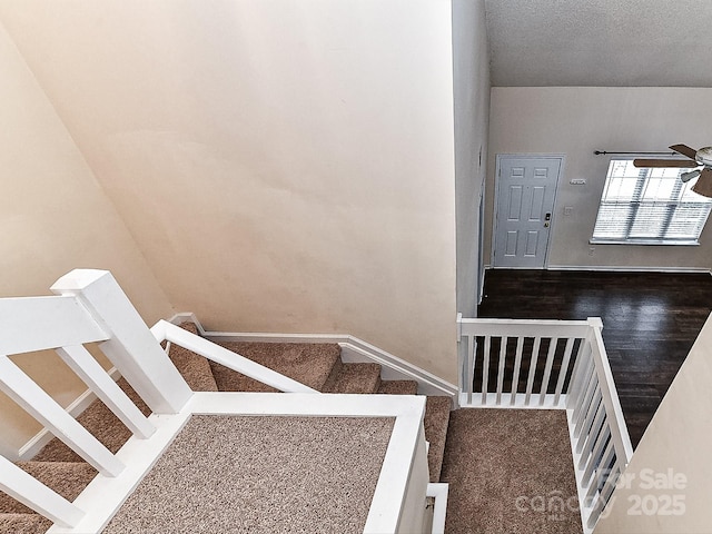 stairway featuring ceiling fan