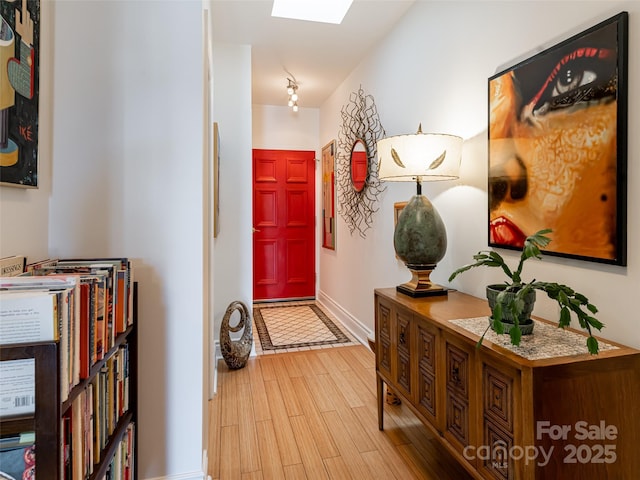 interior space with a skylight and light wood-type flooring