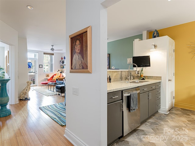 kitchen with sink, gray cabinets, dishwasher, backsplash, and light stone countertops