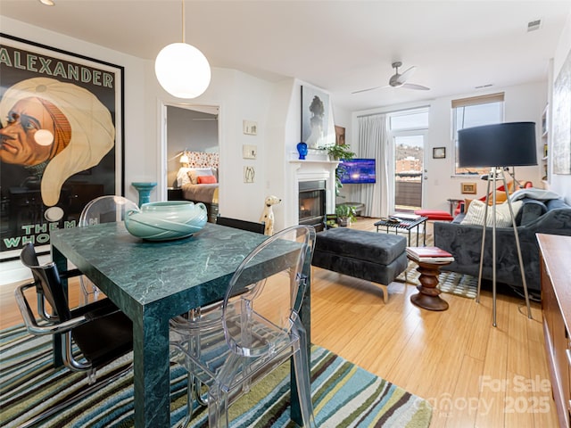 dining area with wood-type flooring and ceiling fan