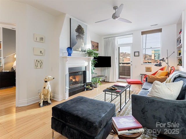 living room with wood-type flooring and ceiling fan