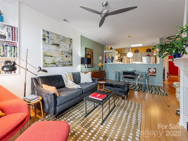 living room featuring ceiling fan and hardwood / wood-style floors