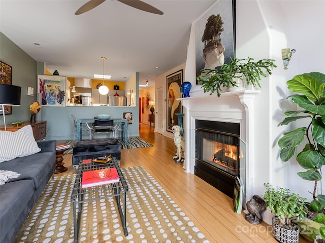 living room featuring ceiling fan and light hardwood / wood-style flooring