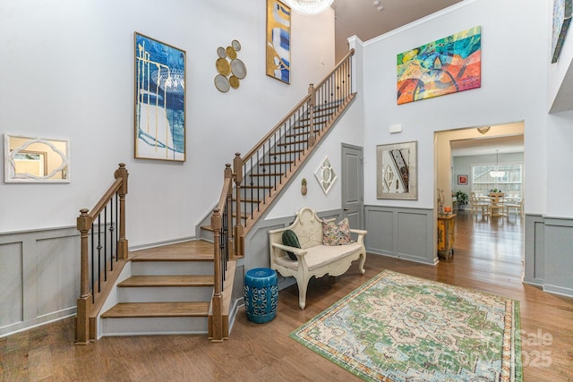 stairs with hardwood / wood-style flooring and a high ceiling