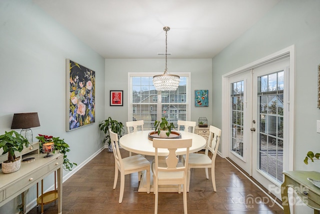 dining room with dark hardwood / wood-style flooring, a notable chandelier, plenty of natural light, and french doors