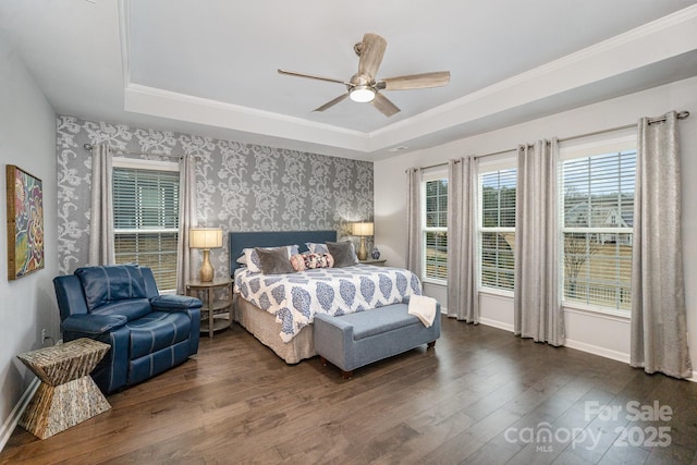 bedroom featuring a raised ceiling, crown molding, dark hardwood / wood-style floors, and ceiling fan