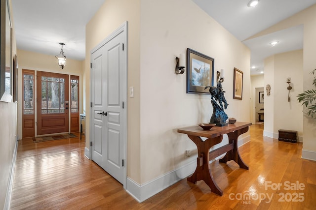 hall featuring vaulted ceiling and light hardwood / wood-style floors