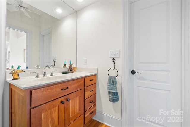 bathroom with hardwood / wood-style flooring, ceiling fan, and vanity