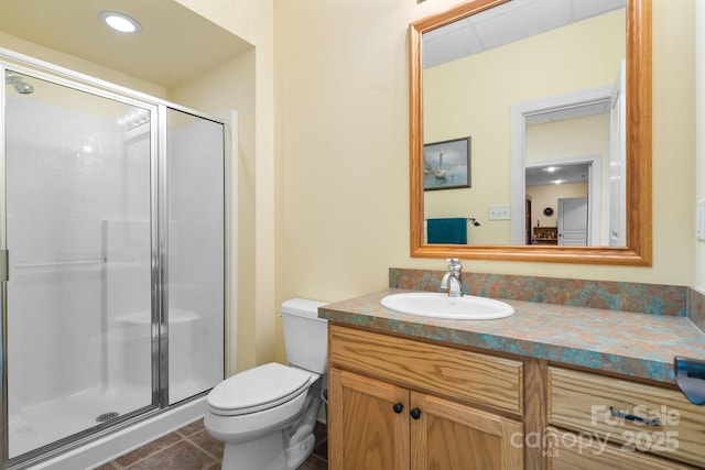 bathroom featuring a shower with door, vanity, tile patterned flooring, and toilet