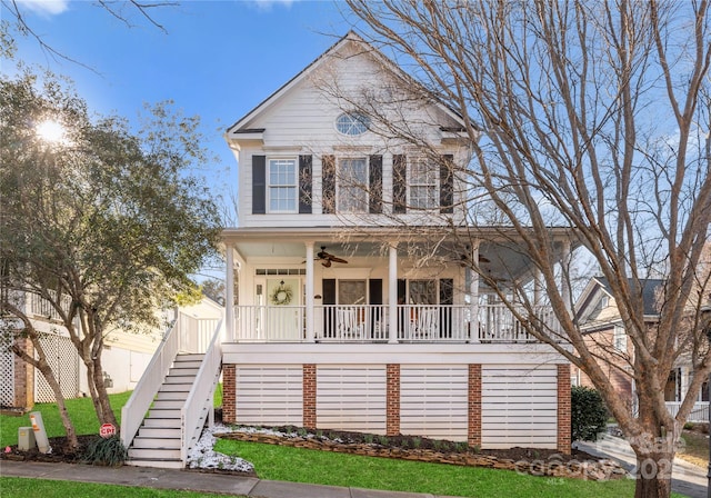 view of front of home with covered porch, ceiling fan, and stairs