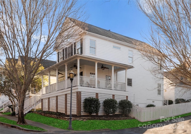 view of front facade with stairs, fence, a porch, and a ceiling fan