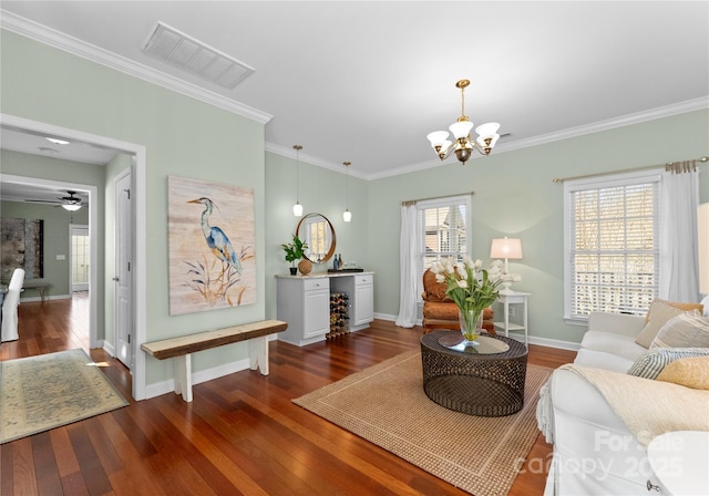 living area featuring dark wood-style floors, crown molding, visible vents, baseboards, and ceiling fan with notable chandelier