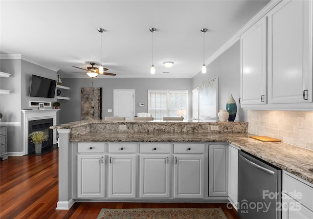 kitchen with a peninsula, white cabinetry, open floor plan, ornamental molding, and decorative light fixtures