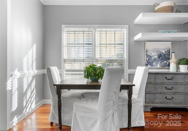 dining area featuring light wood-type flooring and baseboards