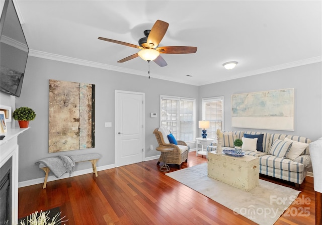 living area featuring ornamental molding, a fireplace, wood finished floors, and baseboards