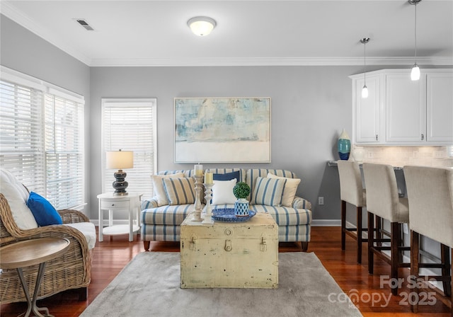 living room with dark wood-type flooring, visible vents, ornamental molding, and baseboards