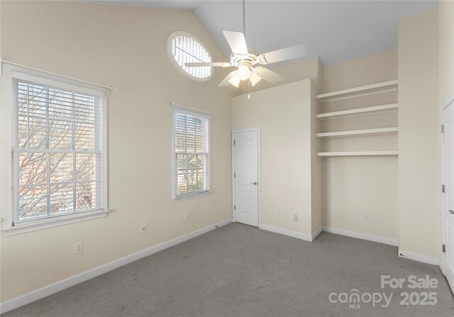 unfurnished bedroom featuring high vaulted ceiling, carpet, and baseboards