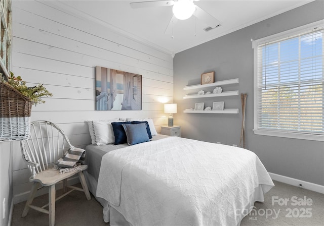 carpeted bedroom featuring baseboards, multiple windows, visible vents, and ornamental molding