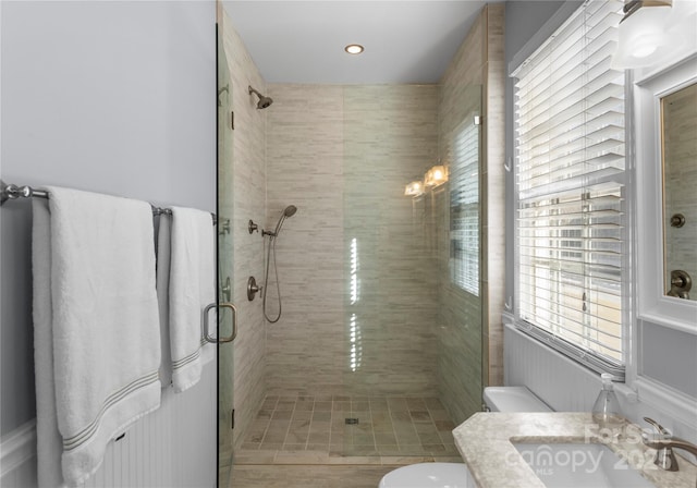 bathroom featuring a shower stall, toilet, and vanity