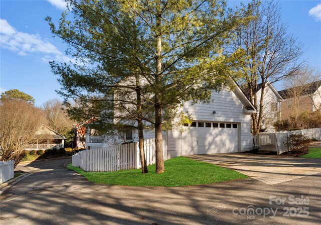 traditional-style home featuring a garage, driveway, and fence