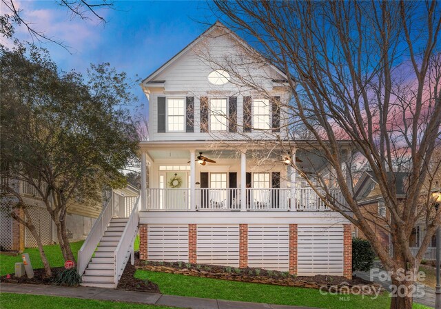 view of front of home with stairs, a porch, and a ceiling fan