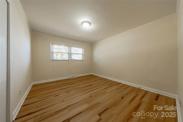 unfurnished room featuring light hardwood / wood-style flooring and ornamental molding