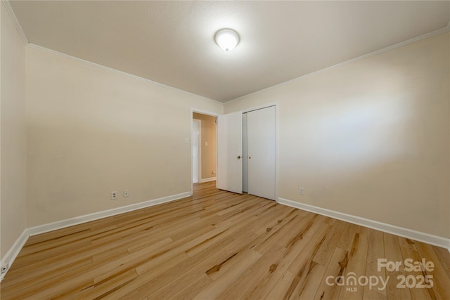 empty room featuring ornamental molding and light wood-type flooring