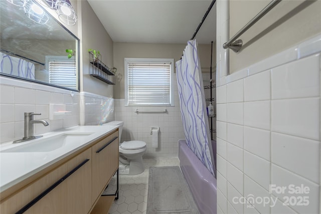 full bathroom featuring tile patterned floors, toilet, tile walls, vanity, and shower / bathtub combination with curtain