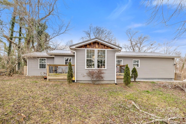 rear view of property with a wooden deck and metal roof