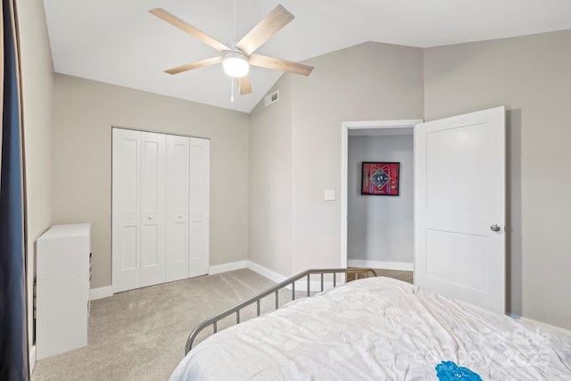 carpeted bedroom with a closet, vaulted ceiling, and ceiling fan