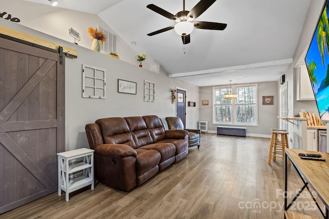 living room with light wood-type flooring, vaulted ceiling, ceiling fan, and a barn door