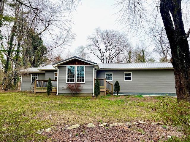 back of house with a deck and a yard