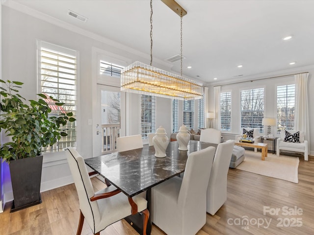 dining area featuring ornamental molding, plenty of natural light, and light hardwood / wood-style floors