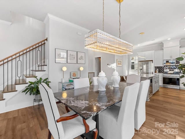 dining room with wood-type flooring and crown molding