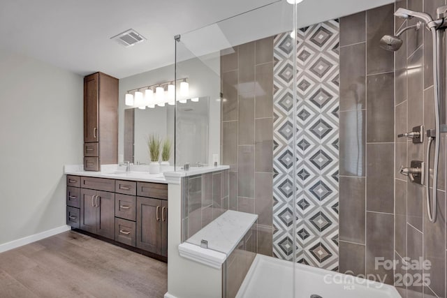 bathroom with vanity, hardwood / wood-style floors, and a tile shower