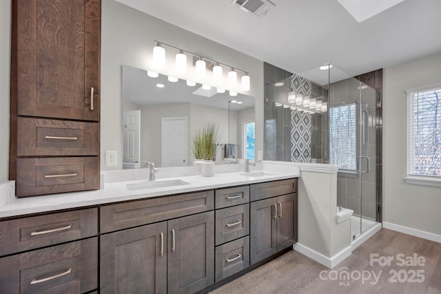 bathroom featuring wood-type flooring, an enclosed shower, and vanity