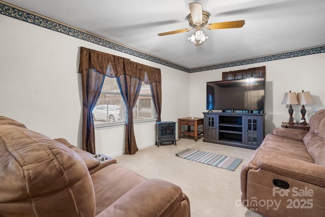 carpeted living room featuring a ceiling fan and baseboards